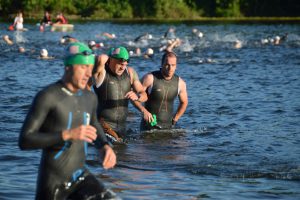 line of triathletes arriving at swim exit