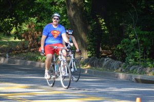 cyclist dressed as Superman including cape